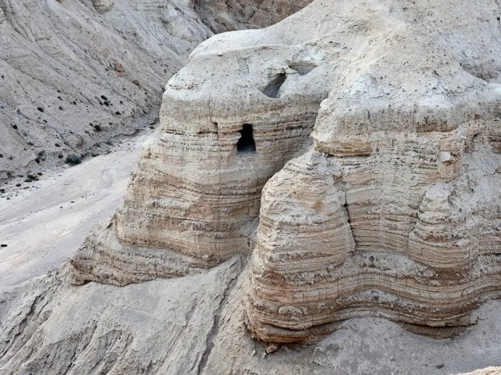Parşömenlerin bulunduğu antik yerleşim yeri Qumran'ın yakınındaki mağaralardan biri. İsrail'de saklanan parşömenler konusunda bir anlaşmazlık var. Ürdün bunları kendisine ait olduğunu iddia ediyor.